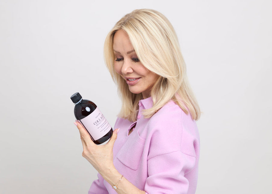 Linda Johansen i rosa genser holder en flaske Collagen Beauty Boost